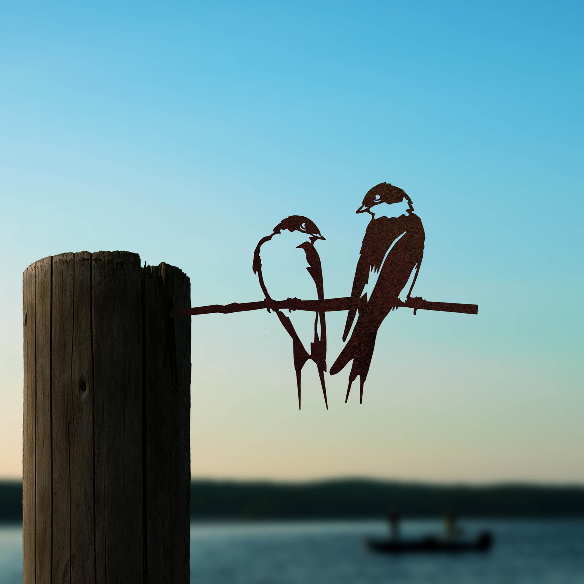 Steel metal bird silhouette and garden ornament in the shape of a pair of swallows.