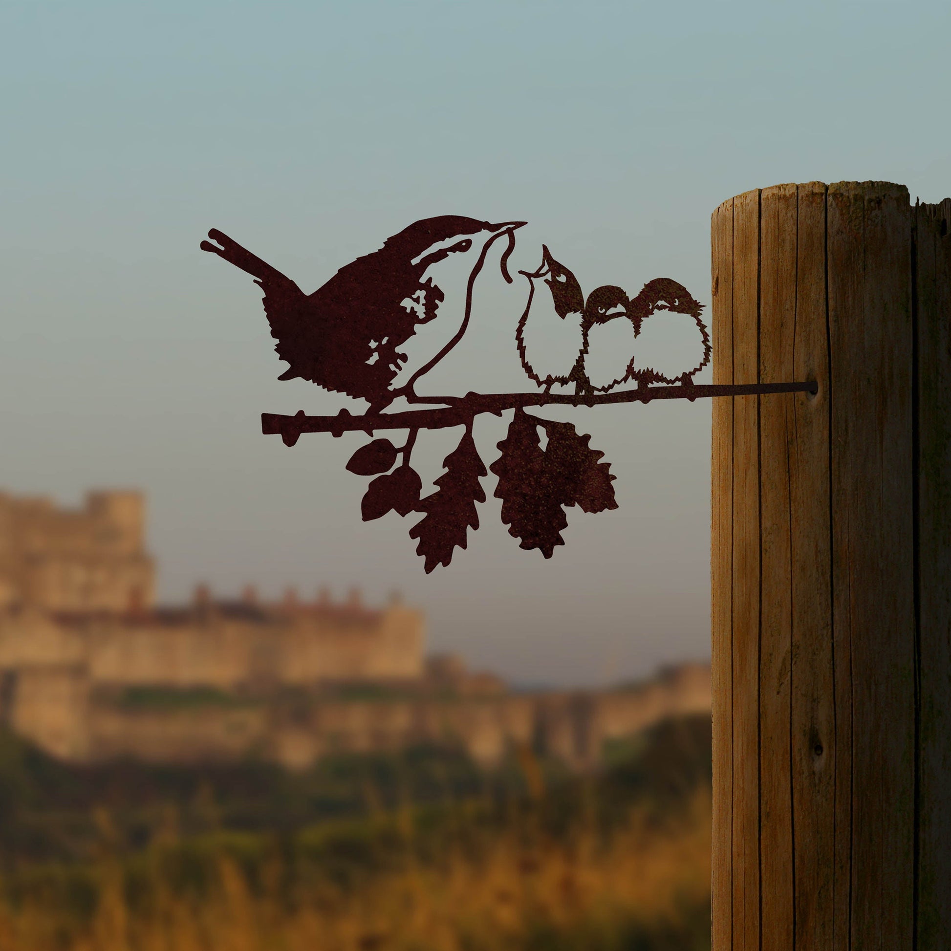 Steel metal bird silhouette and garden ornament in the shape of a wren with its chicks.
