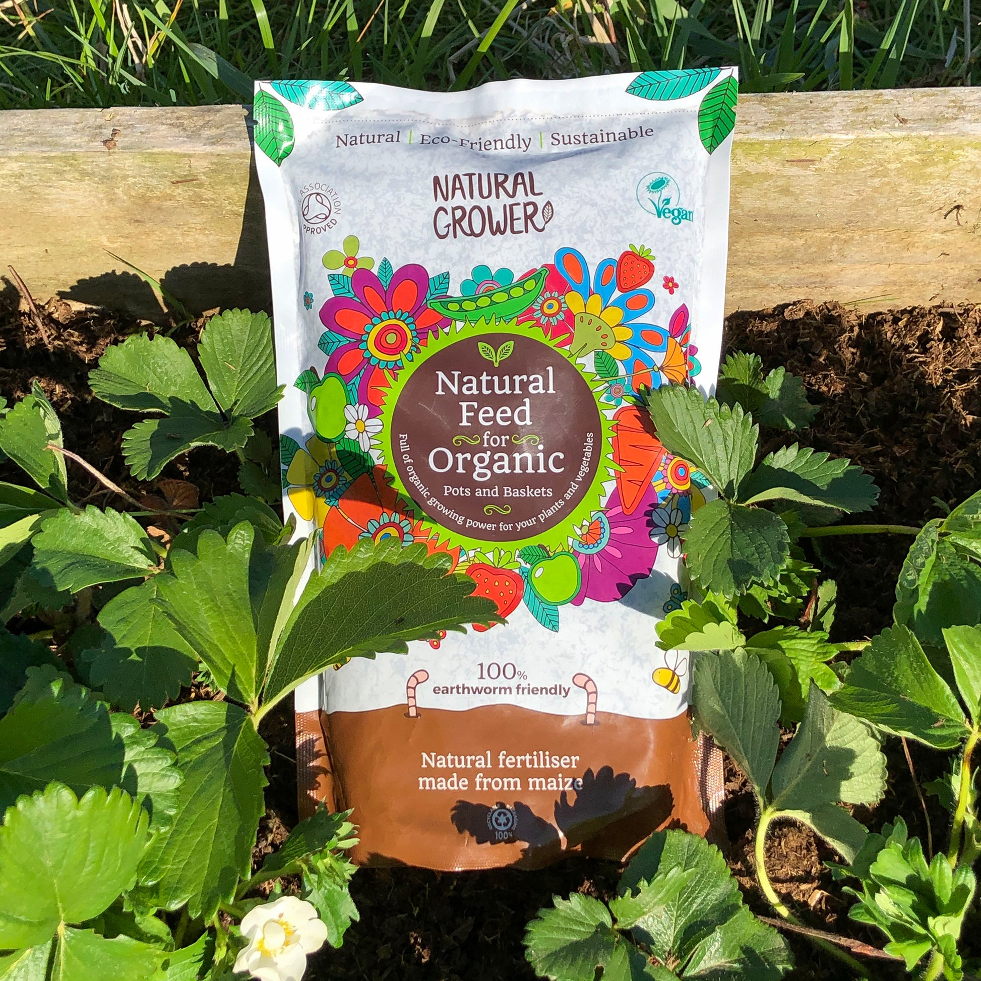 Bag of natural grower organic plant feed in a plant bed.