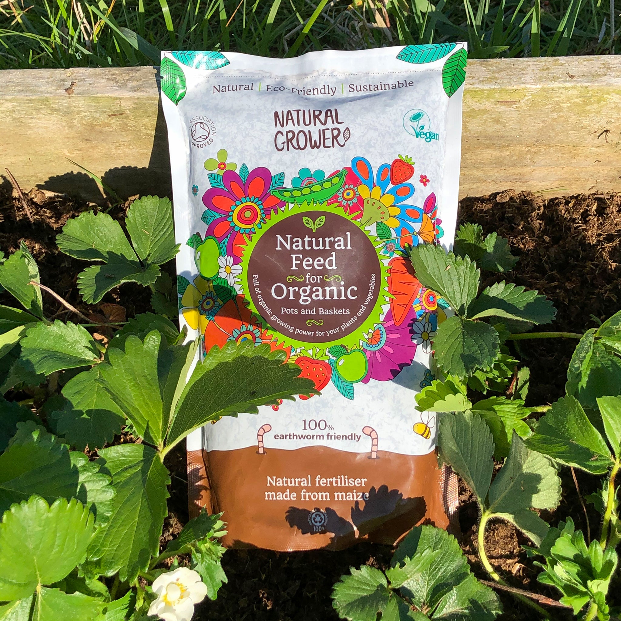 Bag of natural grower organic plant feed in a plant bed.