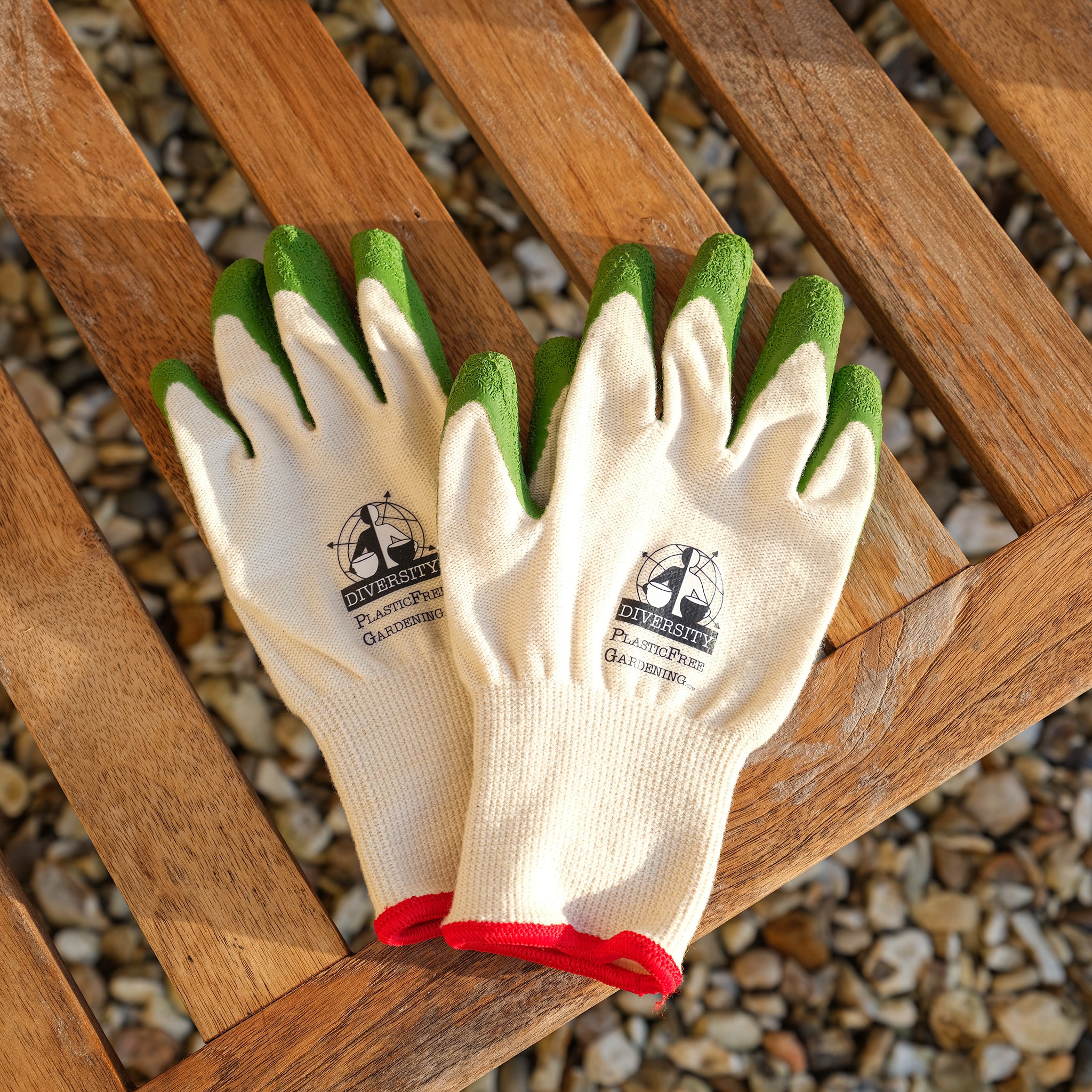 Cream coloured organic cotton gardening gloves with green FSC certified, fair trade natural rubber grips placed on a bench.