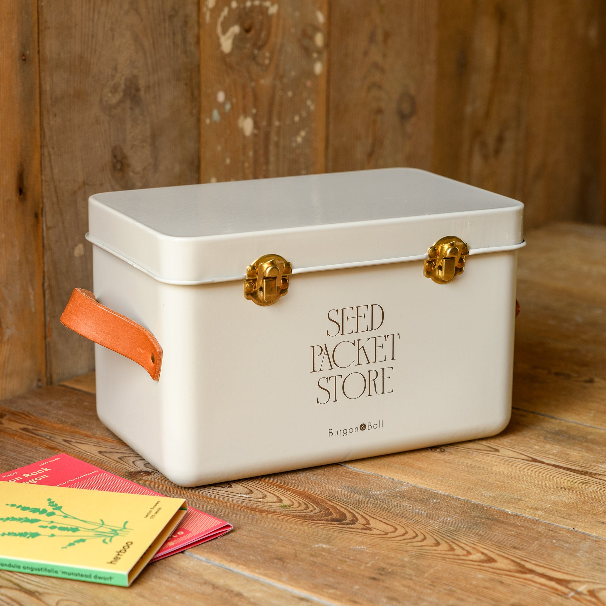 Seed packet storage tin in a mushroom colour placed on a wooden surface with a wooden background.