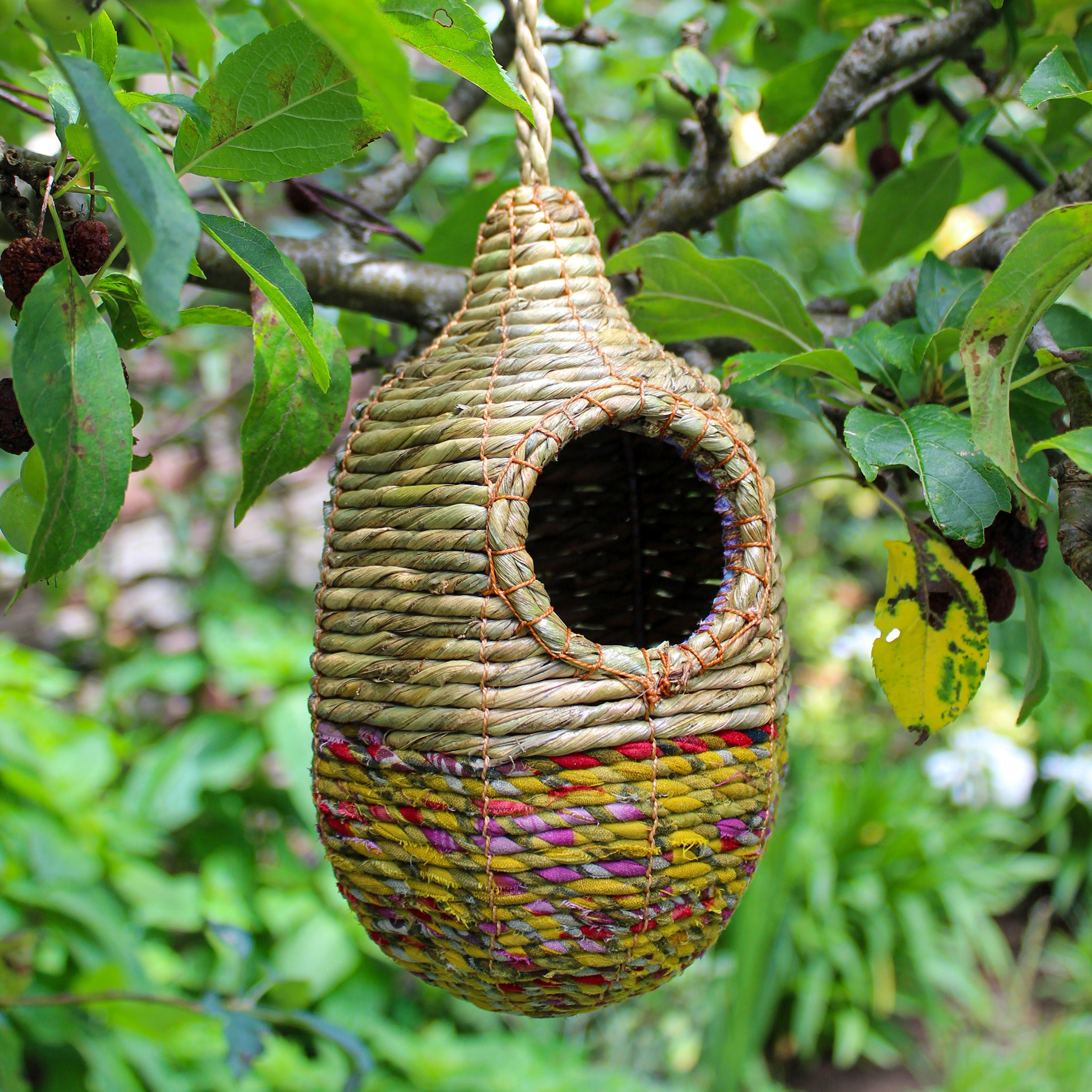 Fair trade, oval, medium sized artisan bird nester made from recycled saris and natural hogla grass.