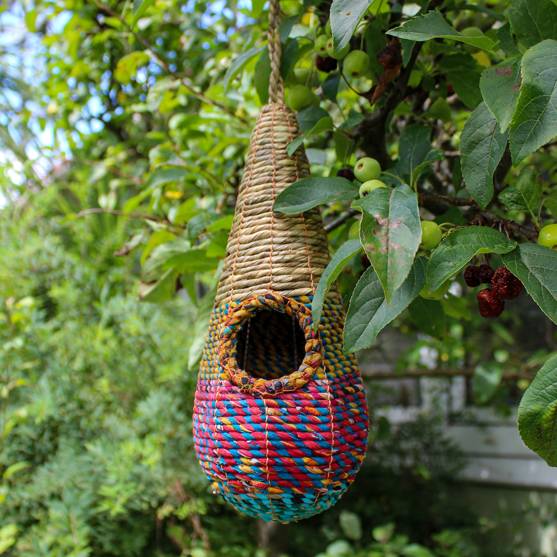 Fair trade, teardrop shaped artisan bird nester made from recycled saris and natural hogla grass.